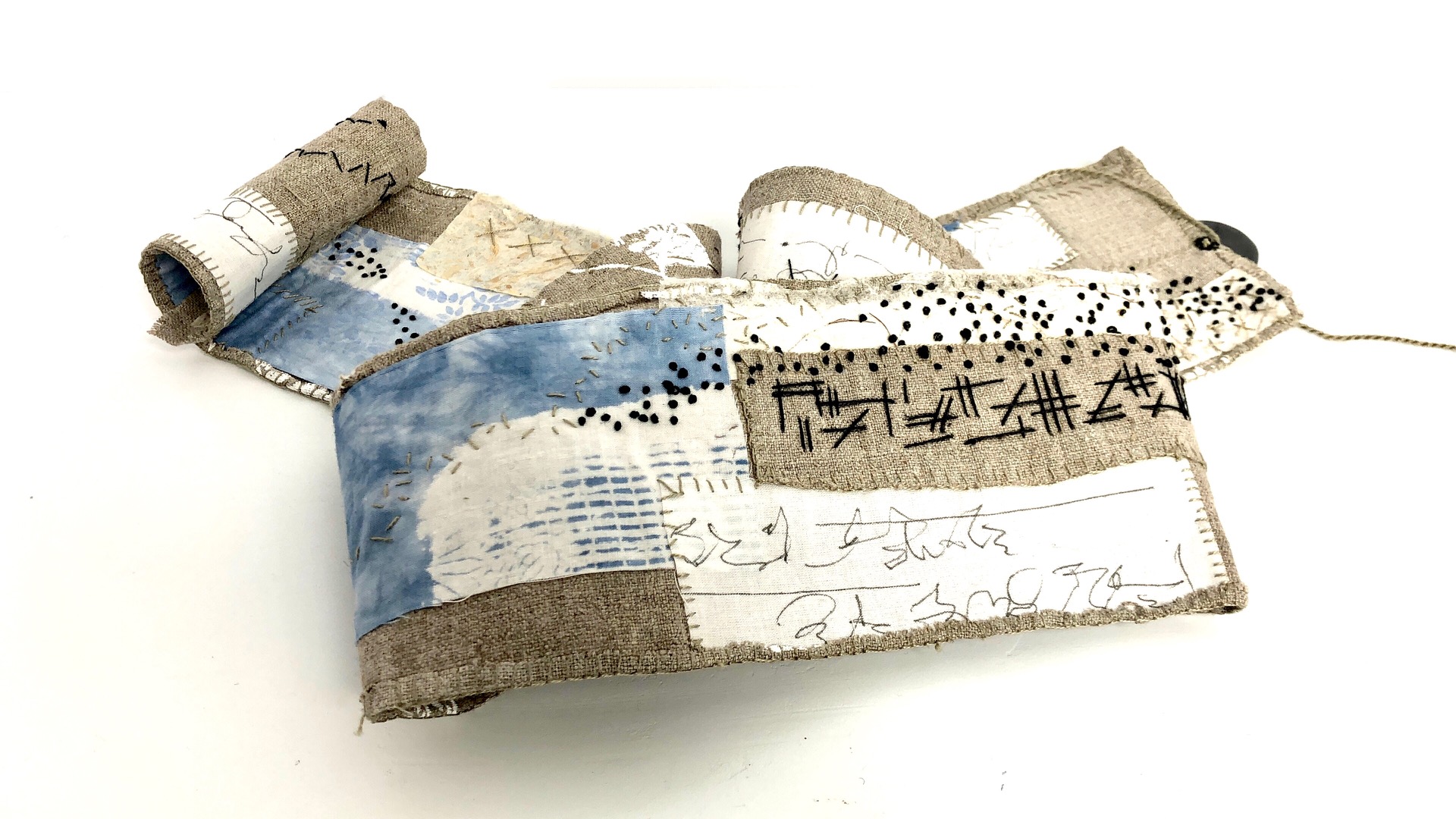 linen strip with black stitching and asymic writing