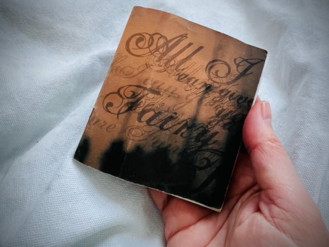 little sketchbook held in a woman's right hand